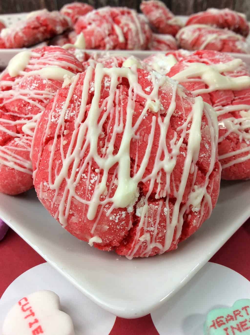 A deliciously and easy Valentine Cake Mix Crinkle Cookie recipe made with a white cake mix and topped with white chocolate drizzle. 