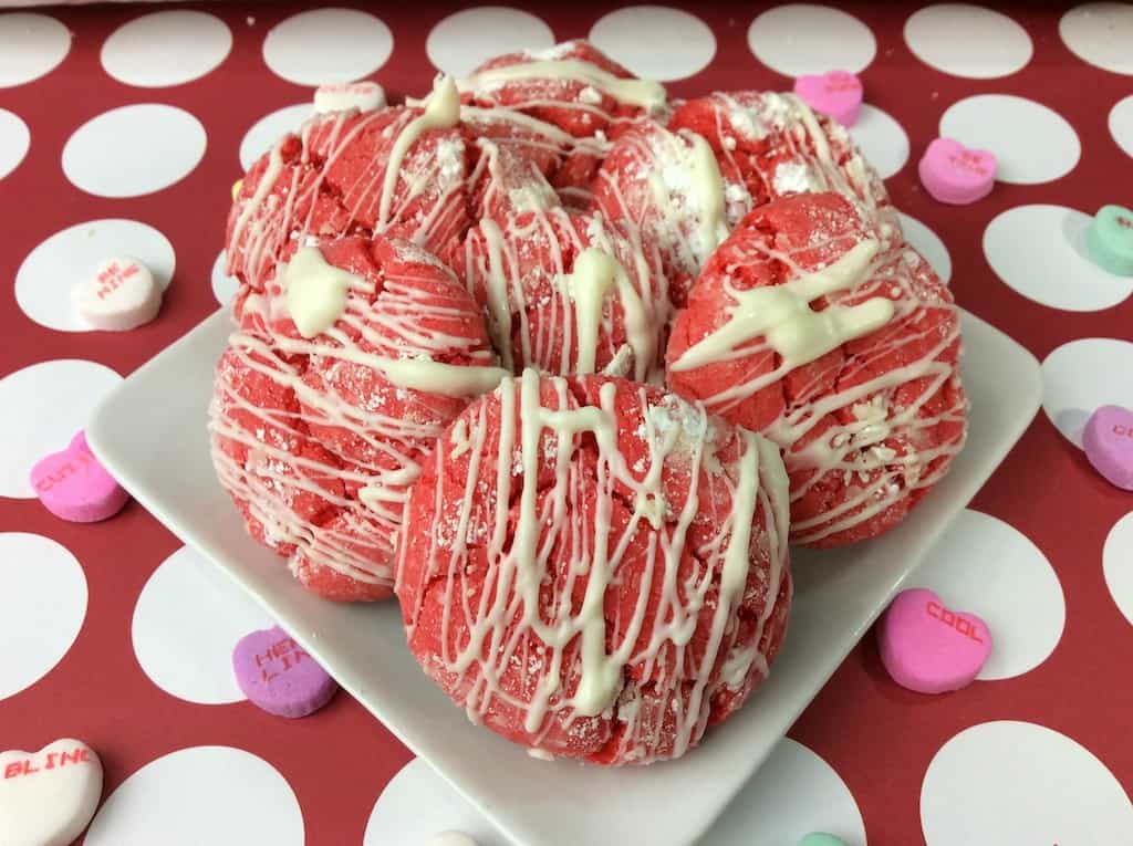 A deliciously and easy Valentine Cake Mix Crinkle Cookie recipe made with a white cake mix and topped with white chocolate drizzle. 