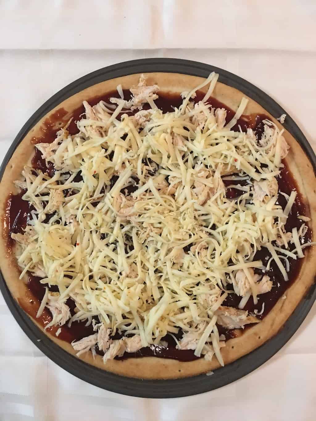 A delicious and easy BBQ Chicken Pizza recipe that can also be made with a cauliflower pizza crust and rotisserie chicken along with your favorite Memphis BBQ sauce. 
