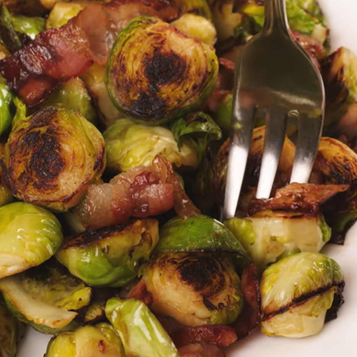 A close-up of perfectly roasted Brussels sprouts with crispy bacon bits, ready to be enjoyed!